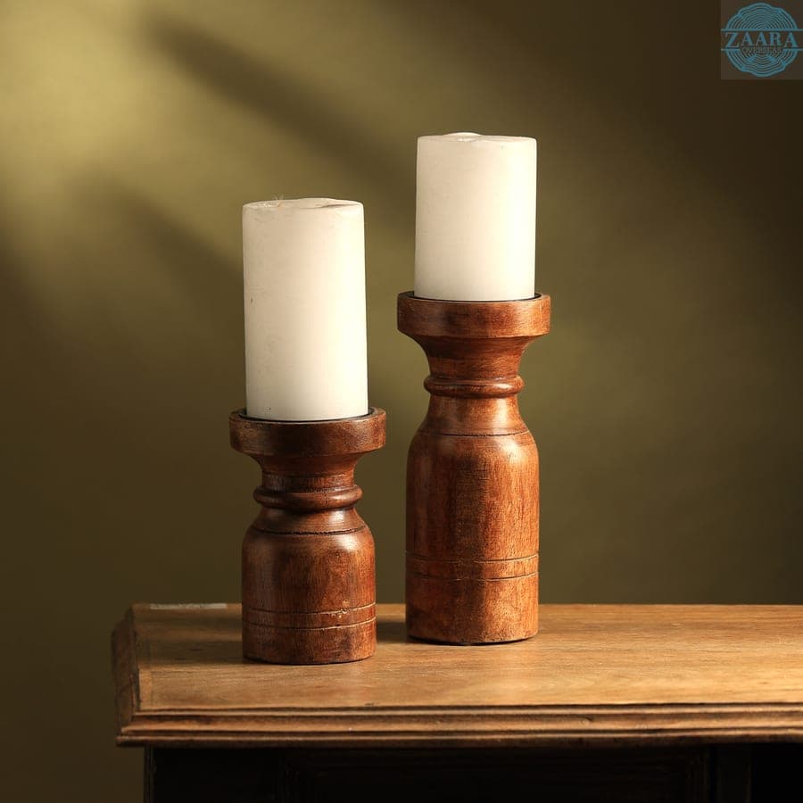 Turned wooden candle holders glowing on a warm tabletop